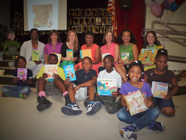 Students pose with books and Big Read Event presenters. Back row-left to right- Sedgefield Principal Ivy Gill, ALP Director Allison Houser, Laurie Martin, Owner of Simplicity Organizers; Sonja Gantt, WCNC; Blair Kingsbury Oliver, Simplicity Organizers; Sophia Crawford, Sedgefield Literacy Coach; Brennan Sheare, Promising Pages’ Erma the Bookworm.